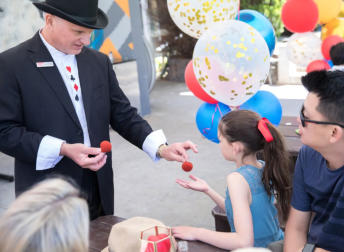 George Stas entertaining a family audience with close up magic